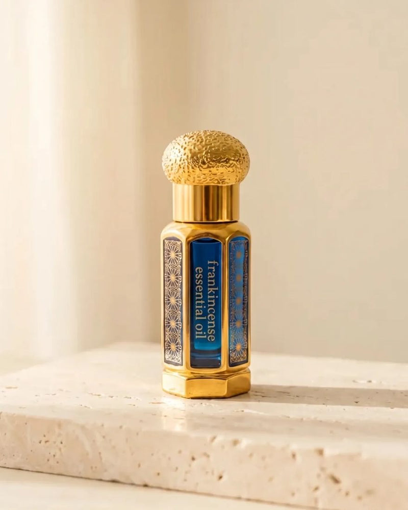 Jade-wierookolie — een klein goud-blauw flesje op een steen